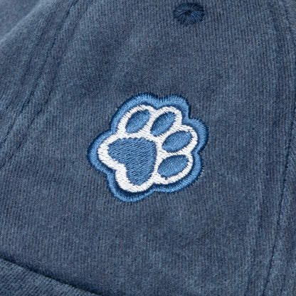 Blue cap with a white paw print logo on a close-up view