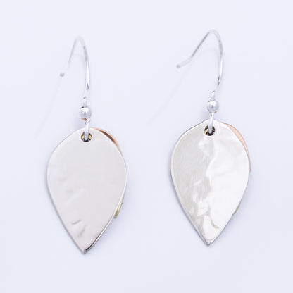Backs of silver leaf-shaped earrings on a light gray background