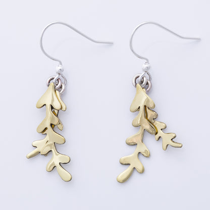 Brass leaf-shaped earrings on a white background