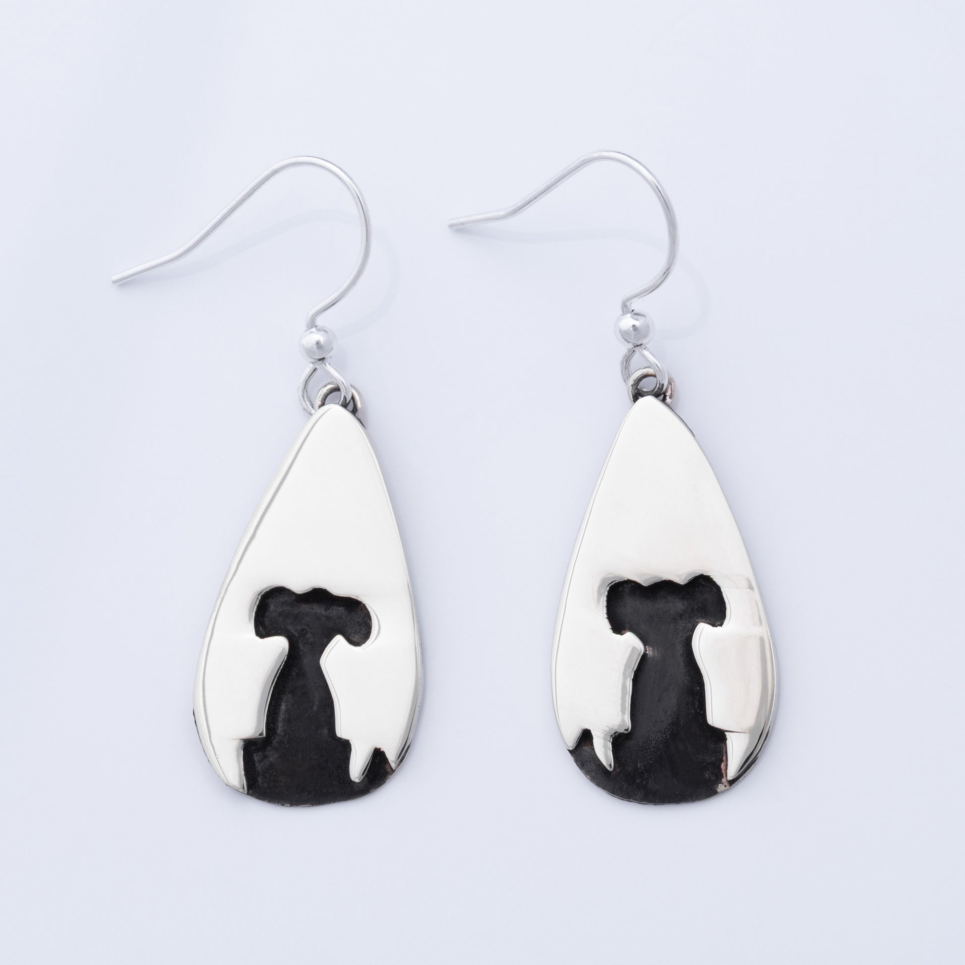 Teardrop-shaped earrings with black and white designs on a light gray background