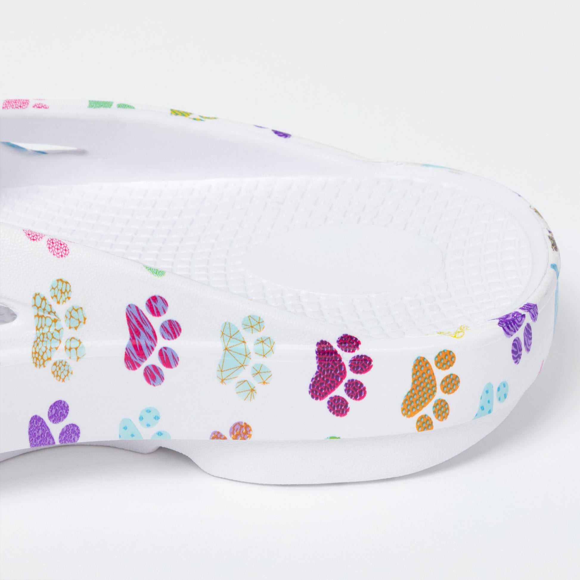 White sandal with colorful paw print designs on a white background