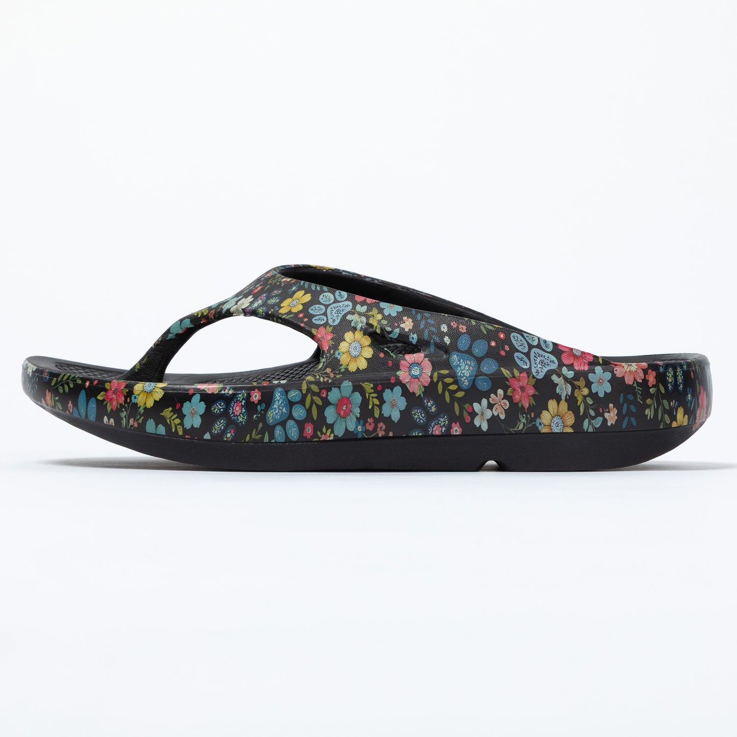 Side view of floral and paw patterned EVA slip on sandal, on a white background.