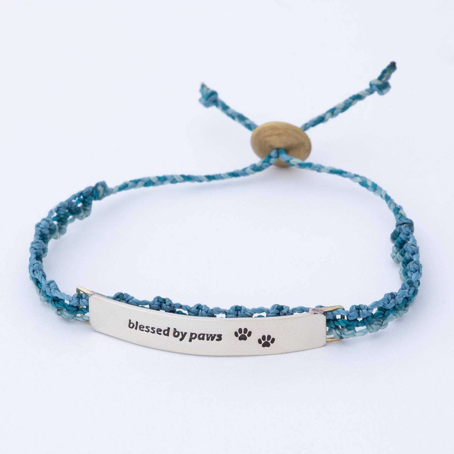 Blue braided bracelet with 'blessed by paws' tag on a white background