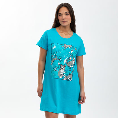 Woman wearing a bright turquoise nightgown featuring playful dog illustrations.