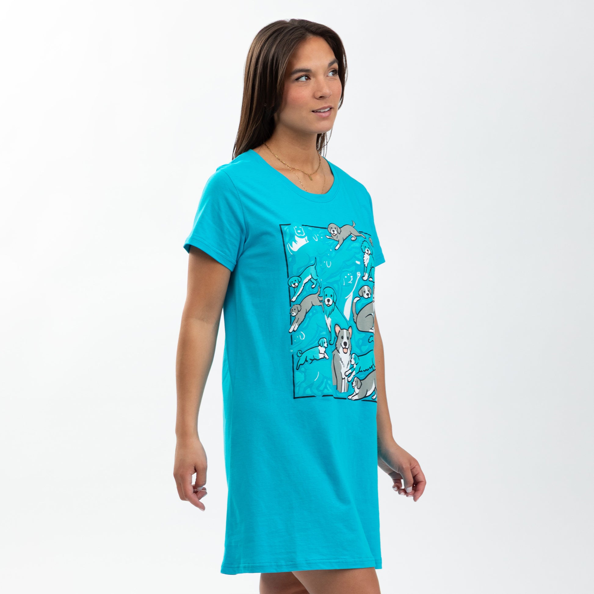 Model wearing a turquoise nightgown featuring playful dog illustrations.