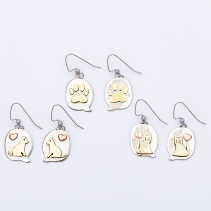 Set of earrings with paw prints and animal illustrations on a light gray background.