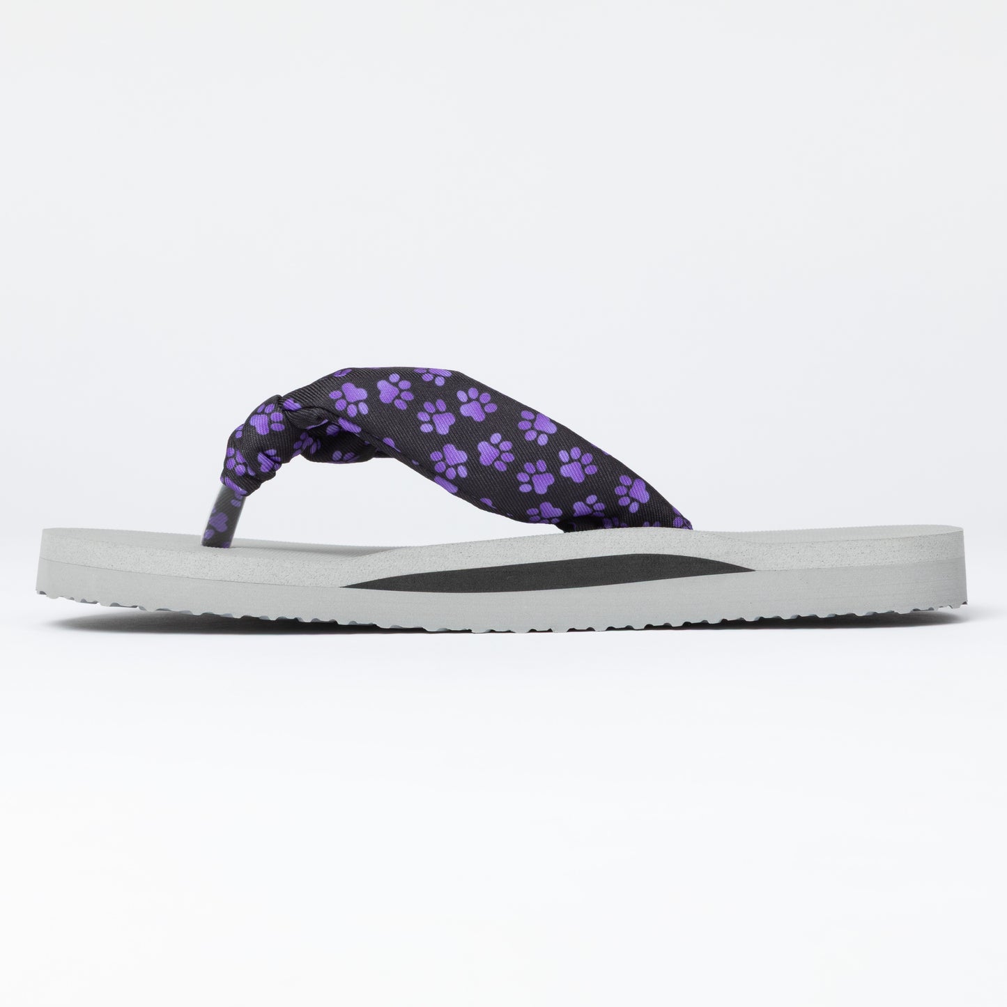 Flip-flop with purple paw print strap on a white background