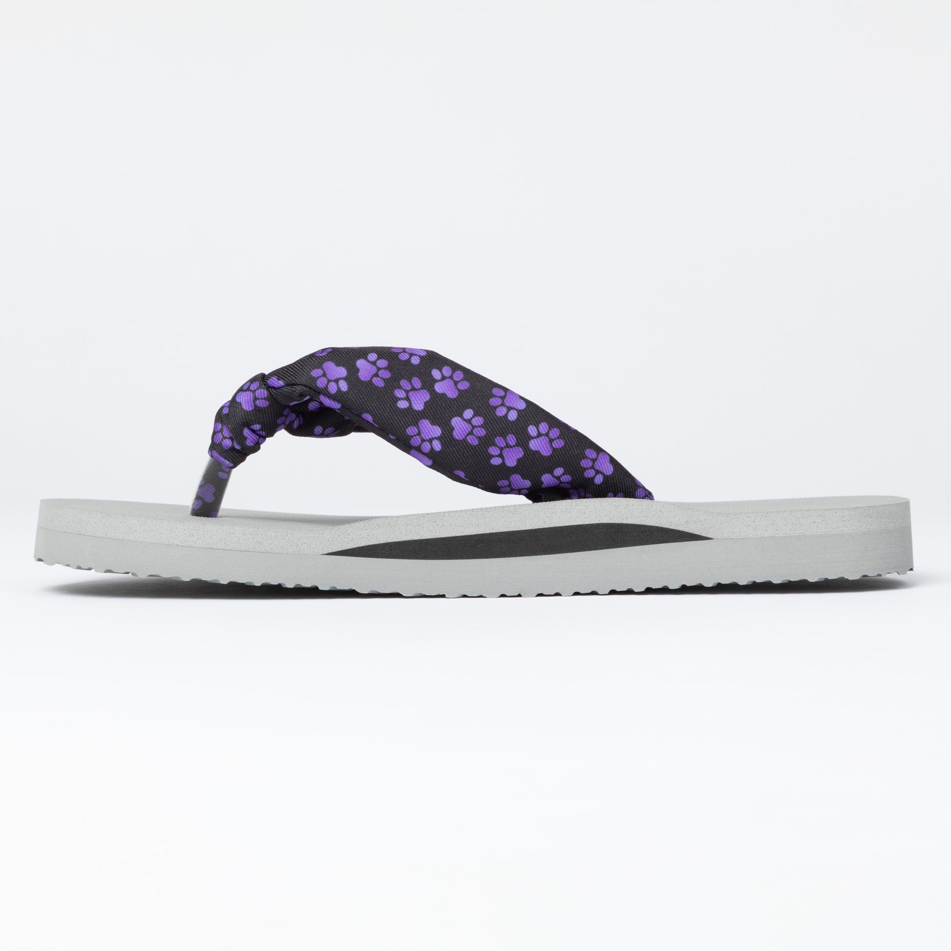 Flip-flop with purple paw print strap on a white background