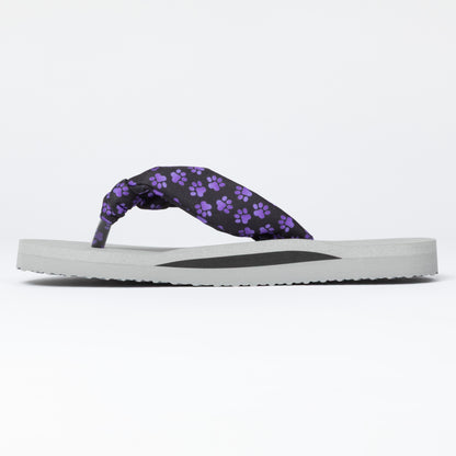 Flip-flop with purple paw print strap on a white background