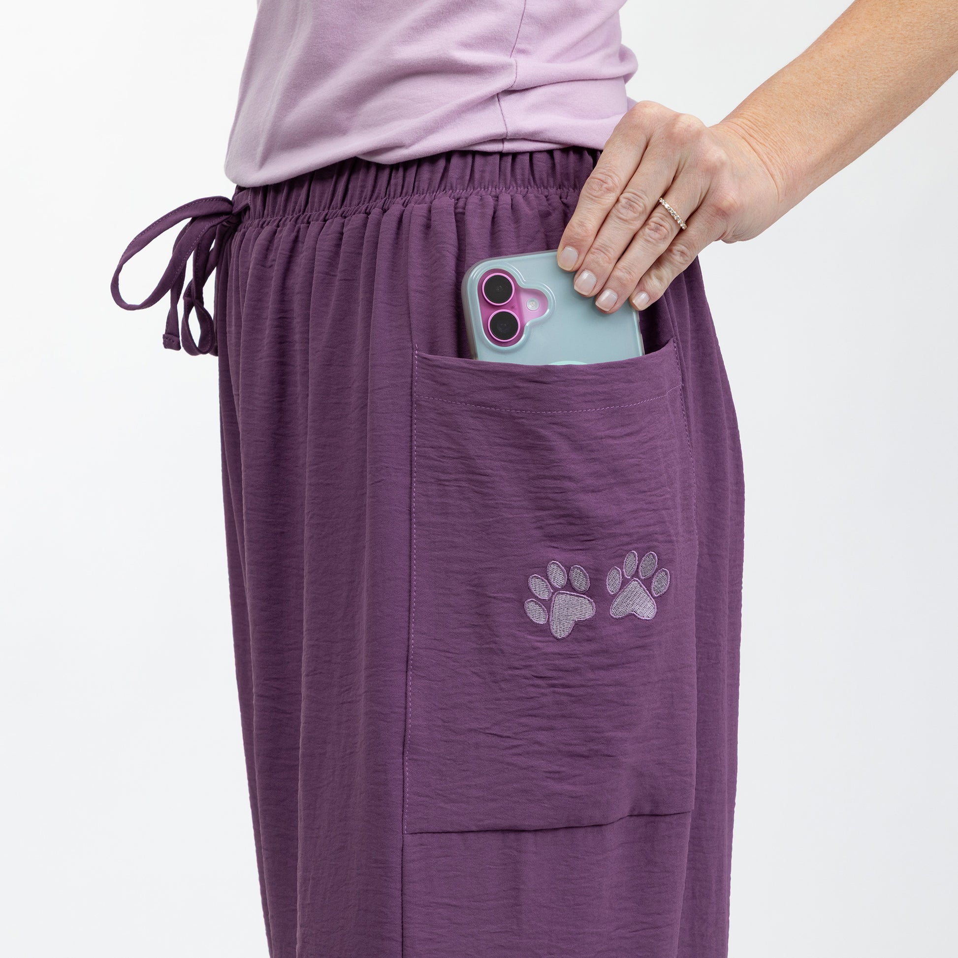 Purple pants with paw prints on a white background