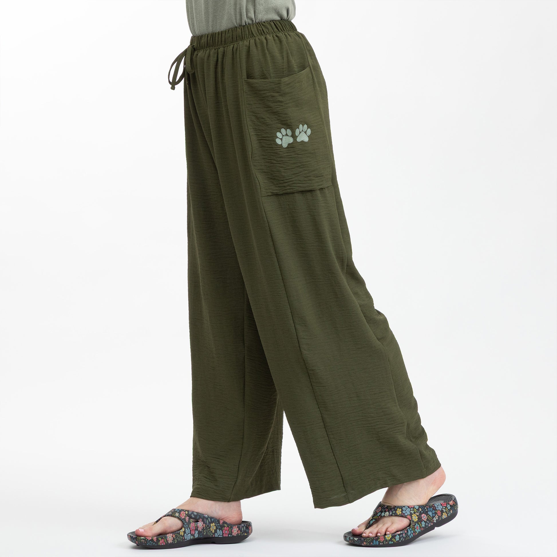 Green wide-leg pants with a paw print on a white background