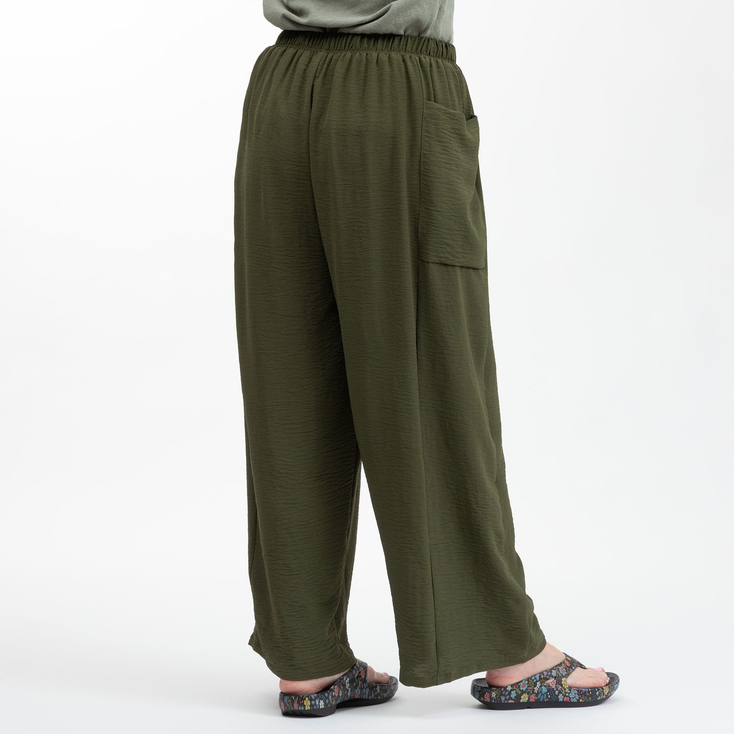 Green wide-leg pants worn by a person on a white background