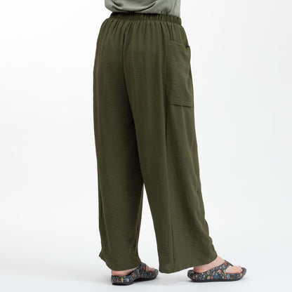 Green wide-leg pants worn by a person on a white background