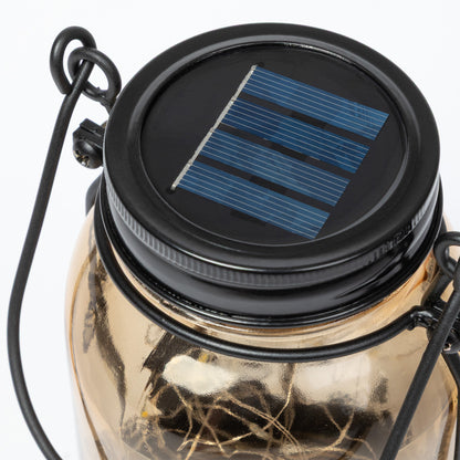 Solar-powered jar lantern with a black lid featuring a solar panel on a white background