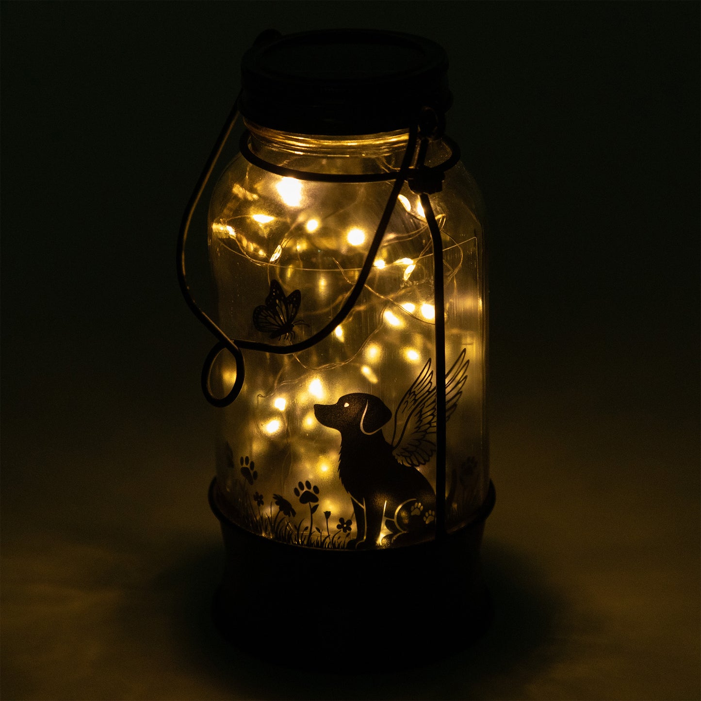 Decorative jar lantern with LED lights and a dog silhouette on a dark background