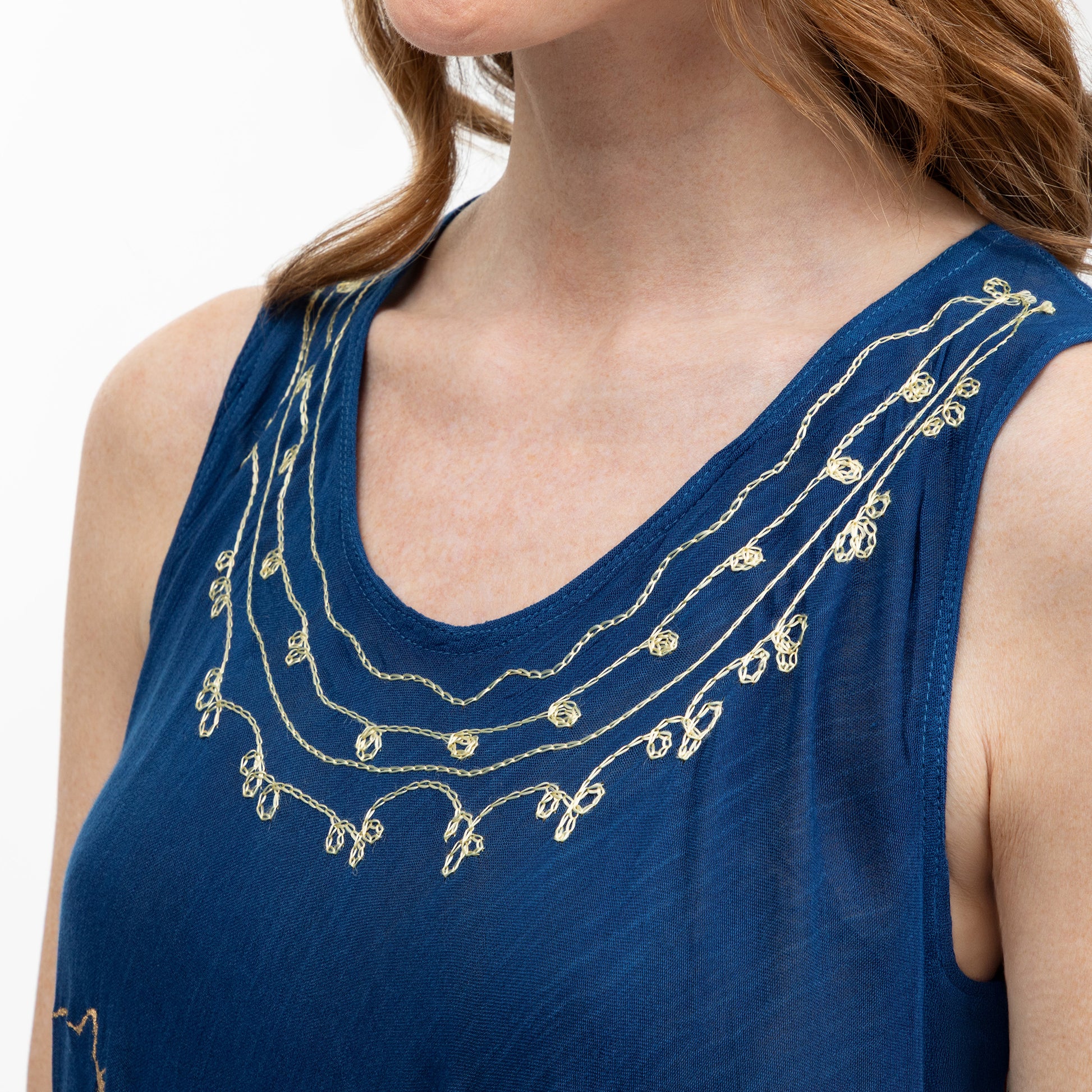 Blue dress top with gold embroidery on a white background