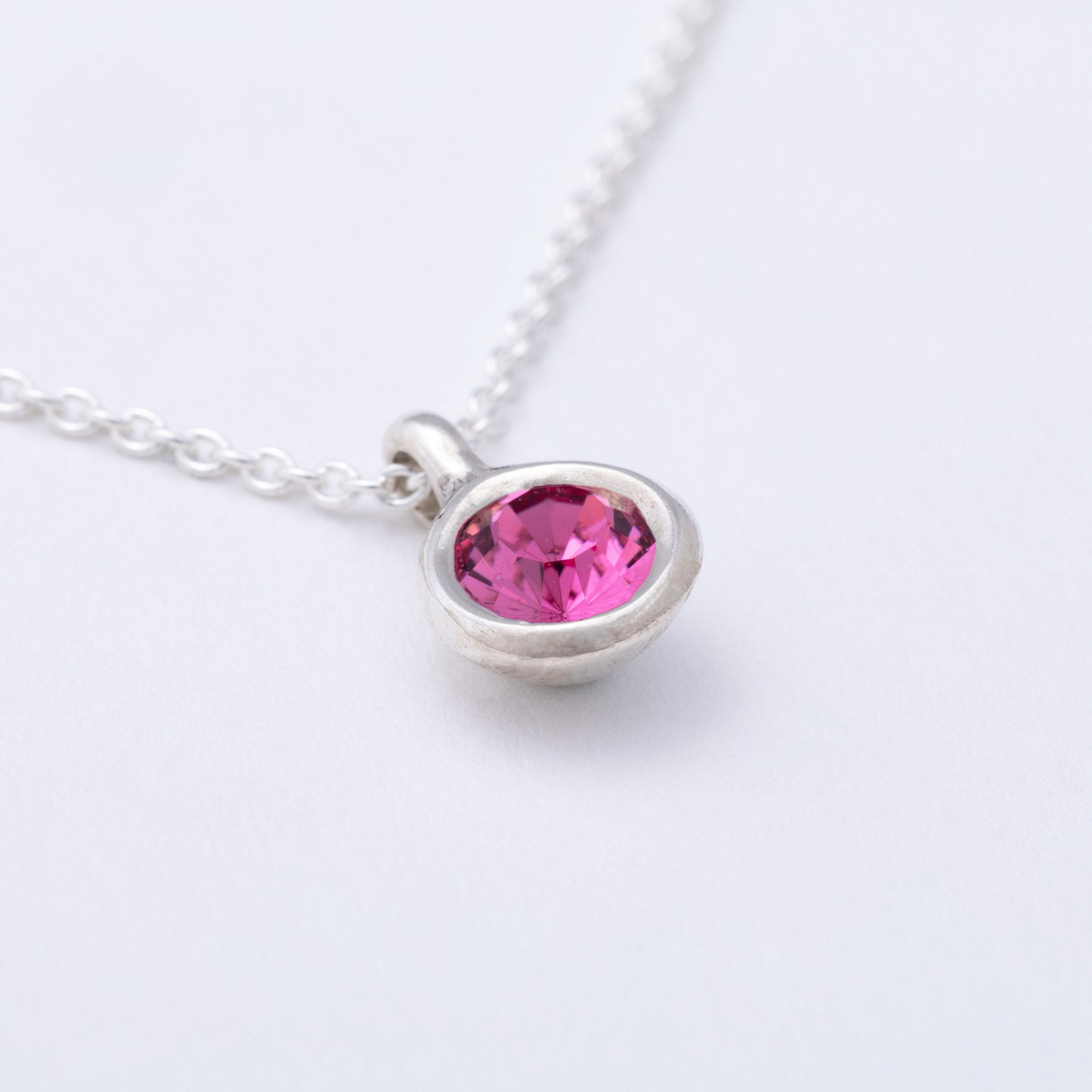 Necklace with a pink gemstone pendant on a white background