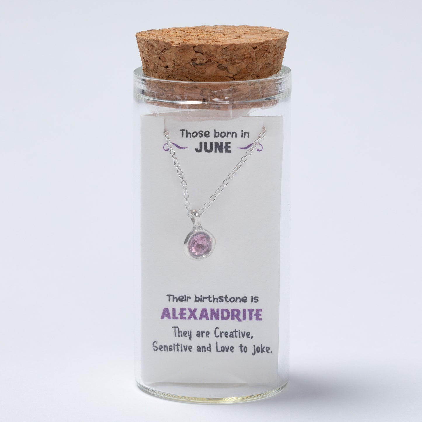 Necklace in a glass jar with cork lid on a white background