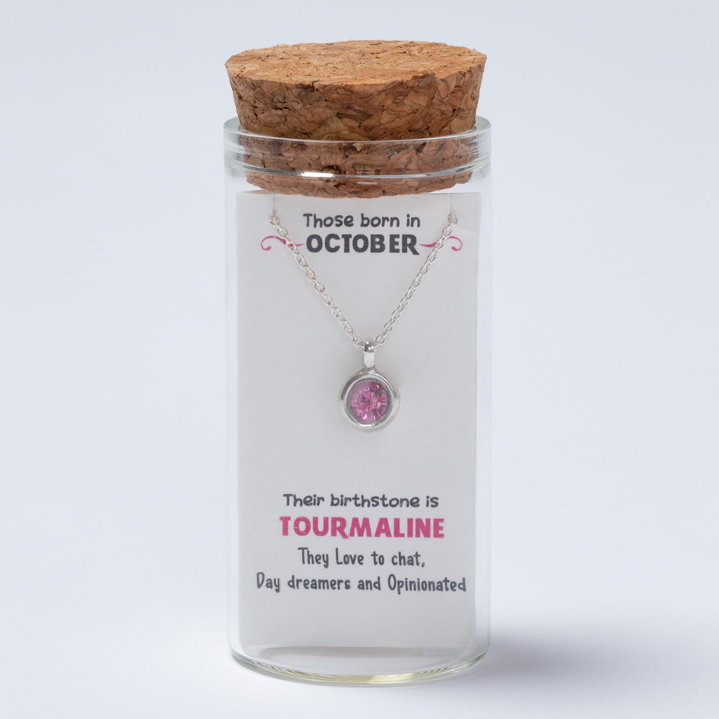Glass jar with cork lid containing a necklace and a card about October-born individuals and their birthstone.