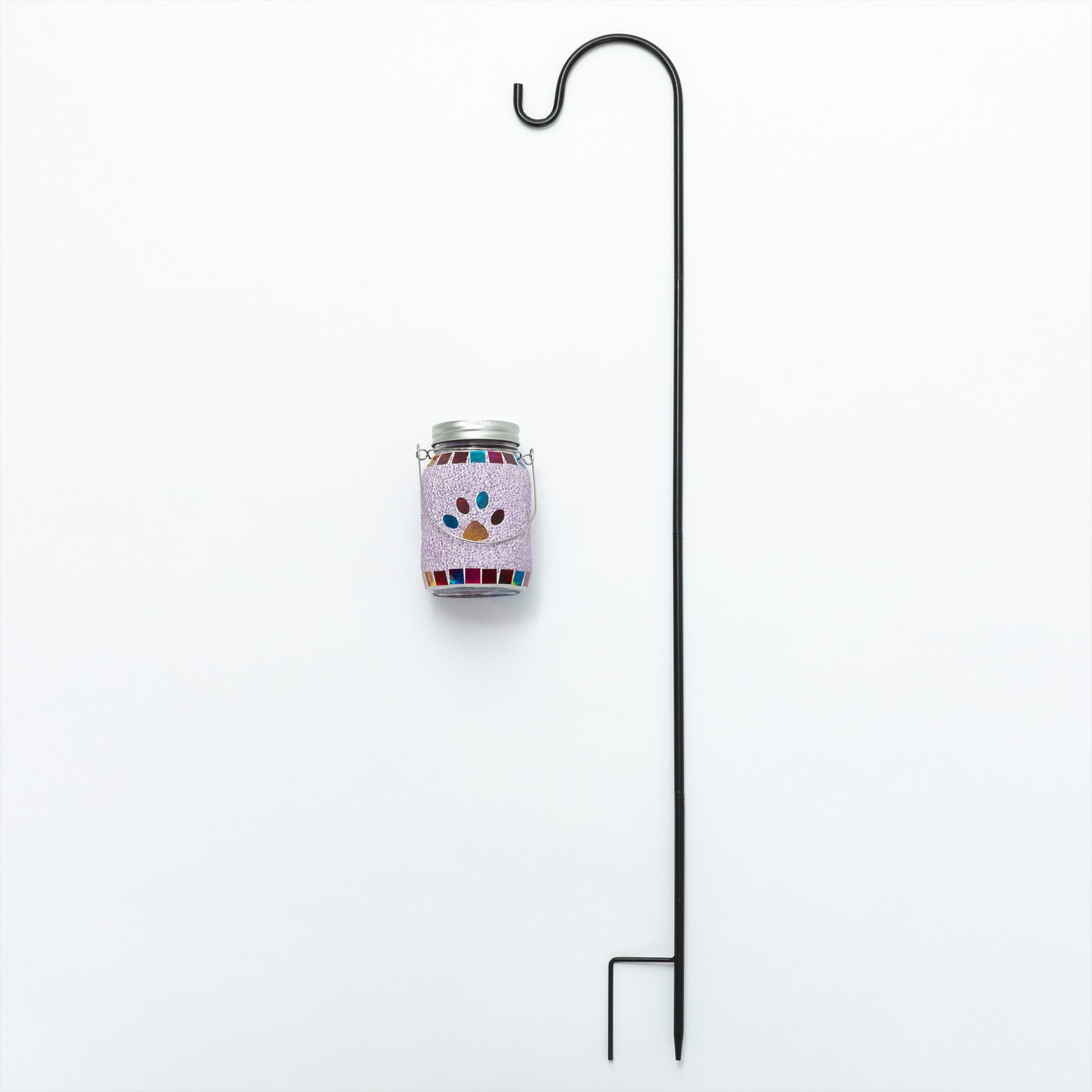 Decorative jar with colorful paw prints on a white background, attached to a black metal stand.