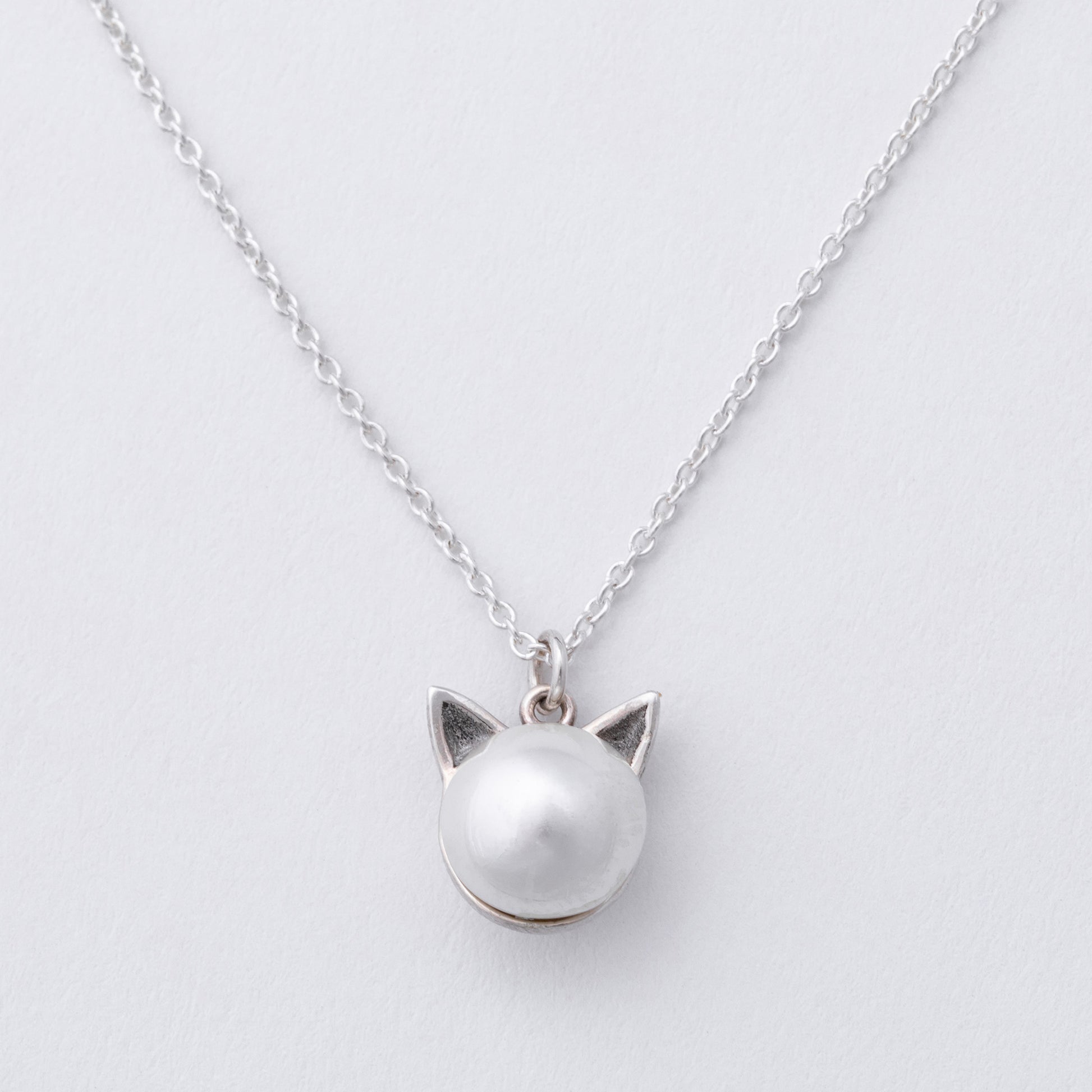 Silver cat-shaped pendant necklace on a light gray background