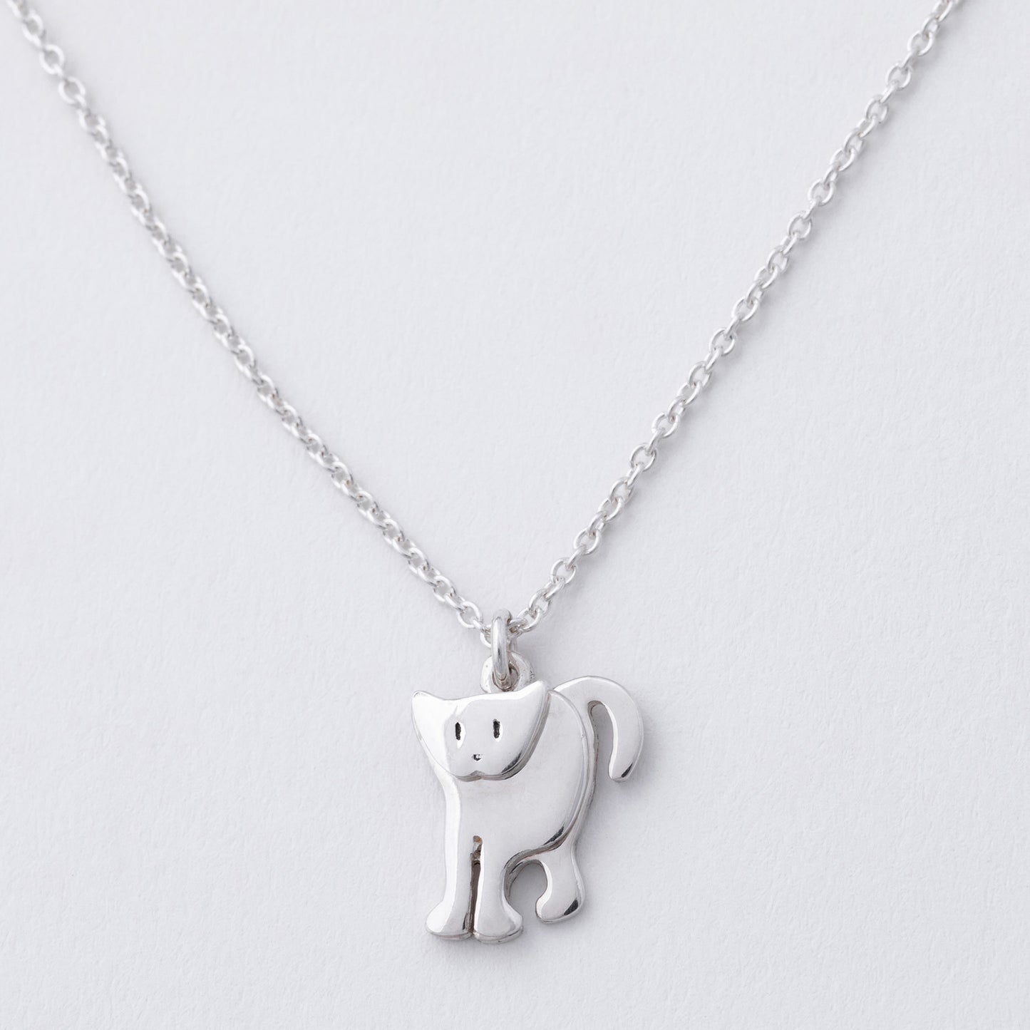 Silver cat-shaped pendant on a chain against a light gray background