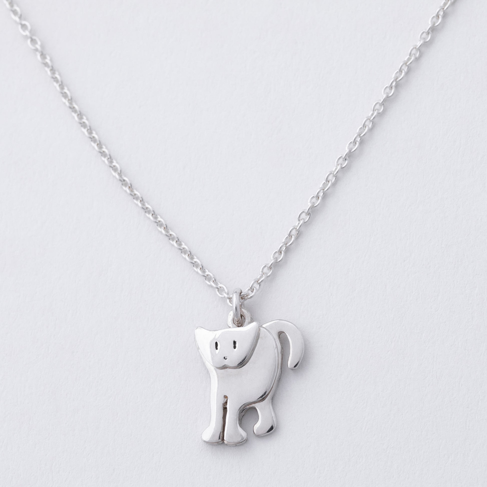 Silver cat-shaped pendant on a chain against a light gray background