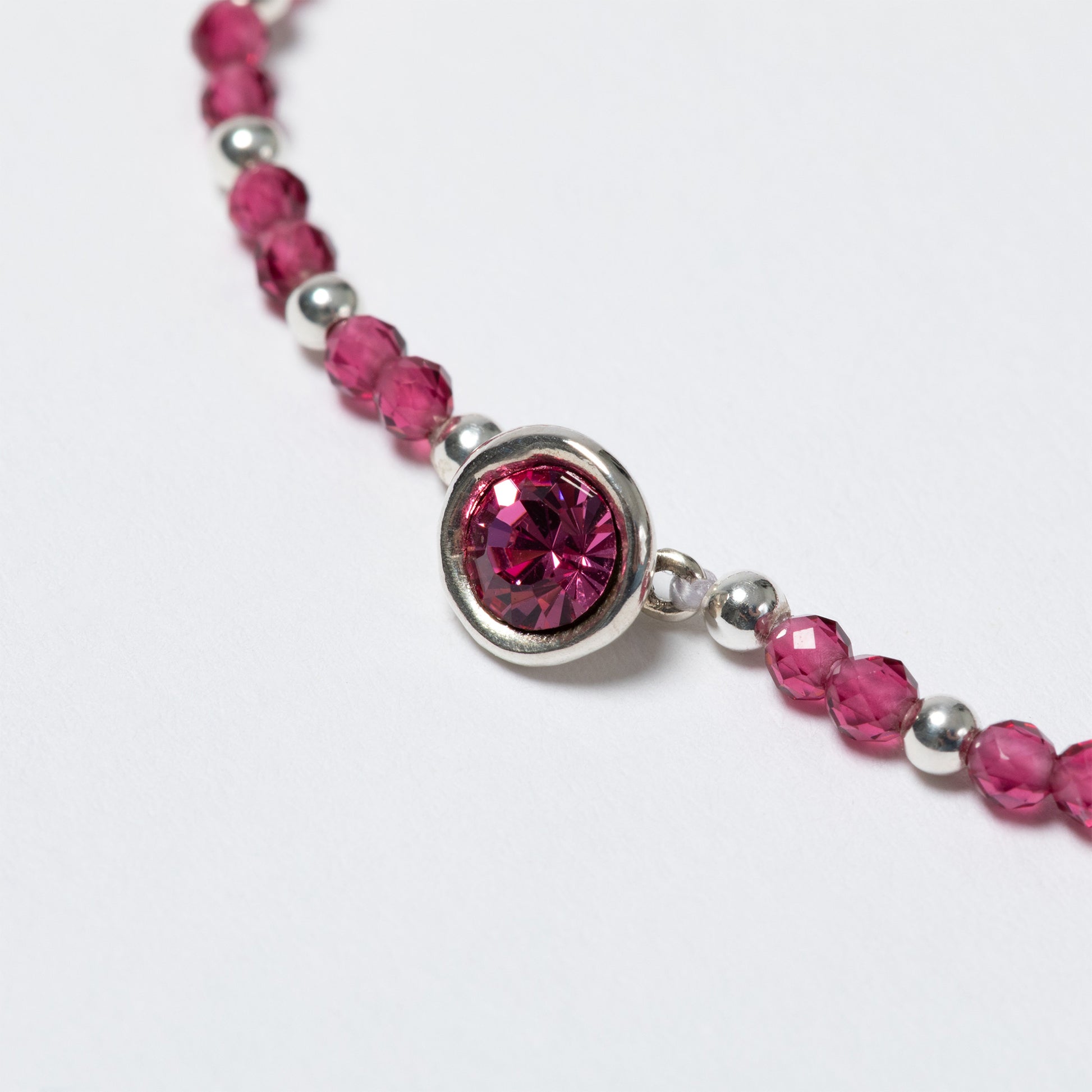 Bracelet with pink beads and a silver clasp on a white background