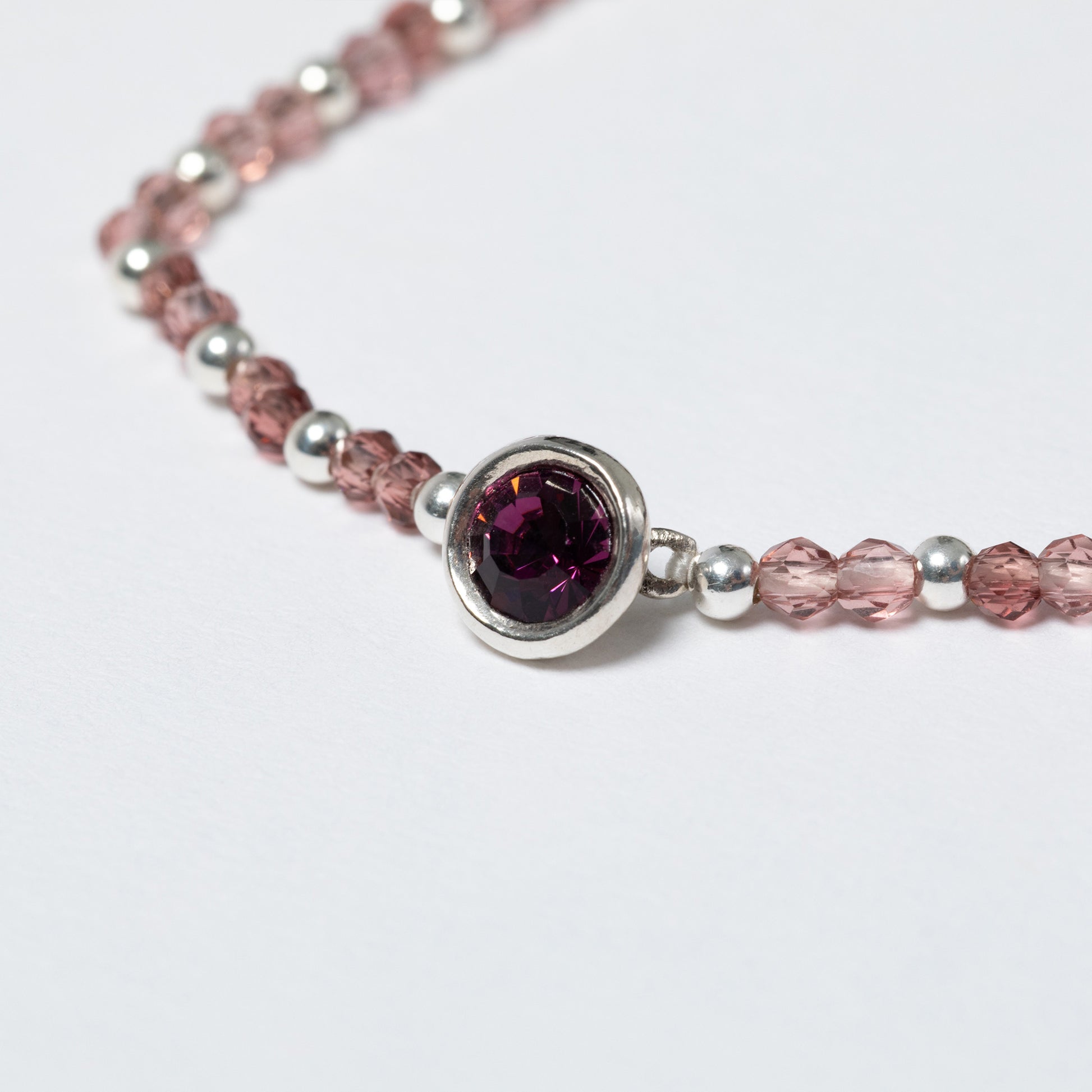 Bracelet with pink and silver beads on a white background