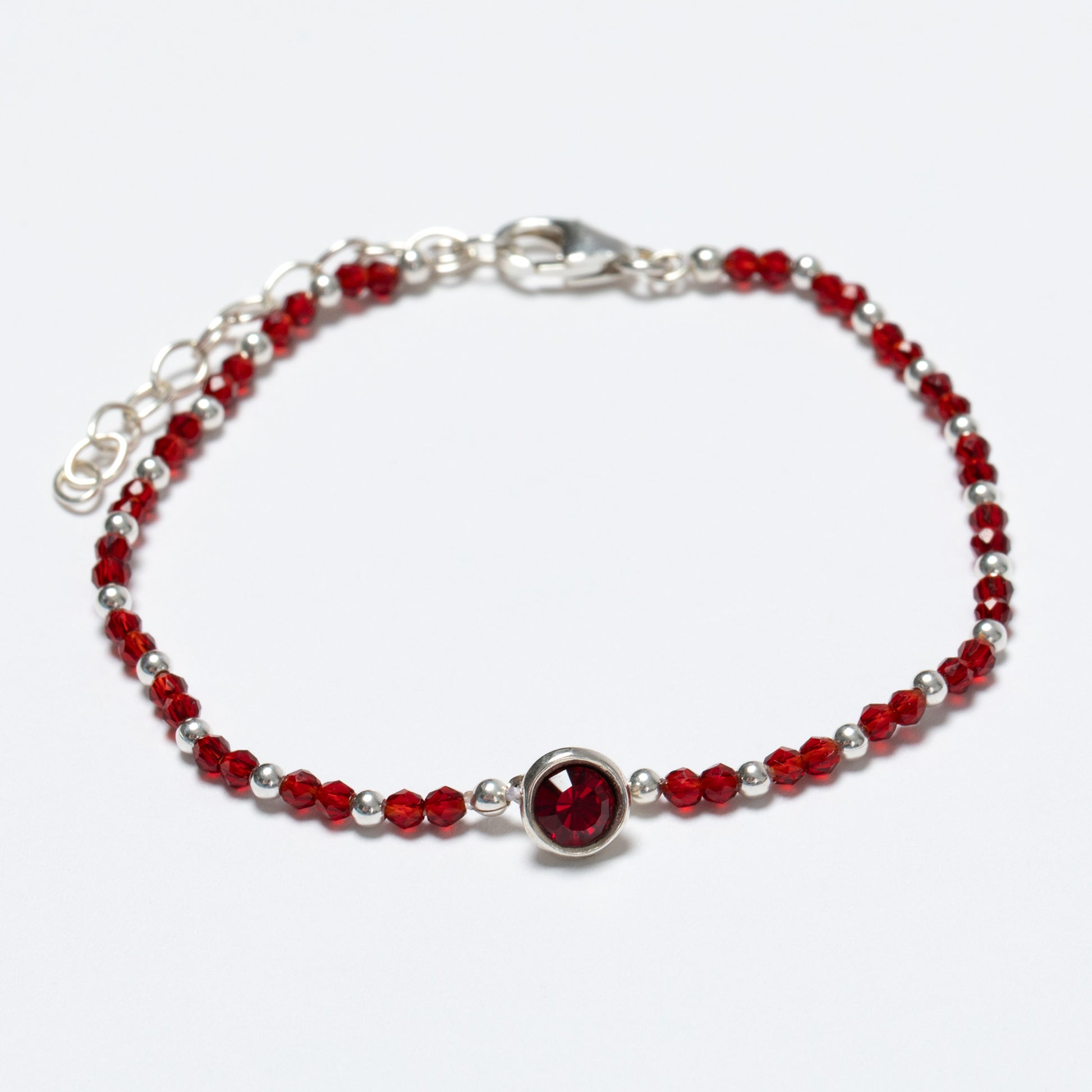 Bracelet with red beads and a silver clasp on a white background