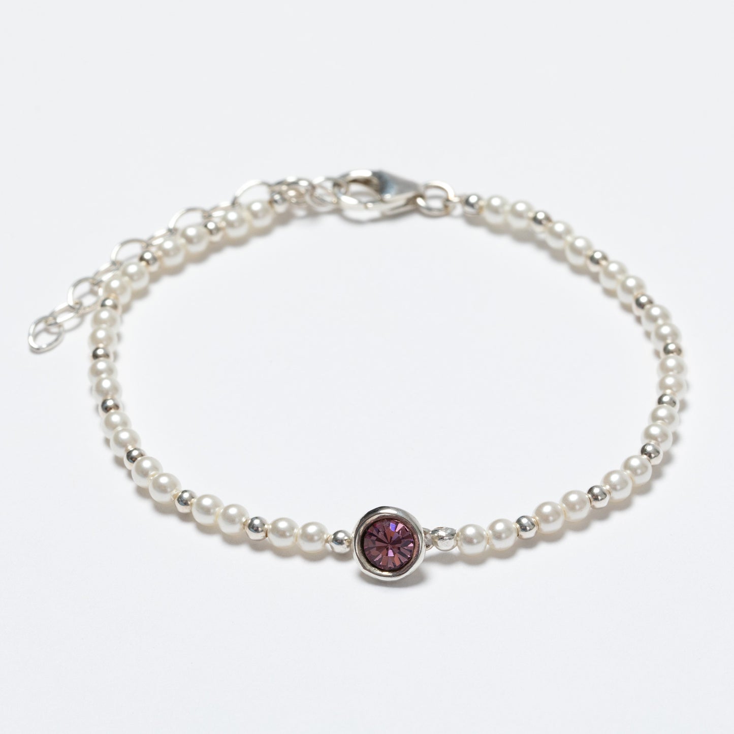 Pearl bracelet with a pink gemstone on a white background