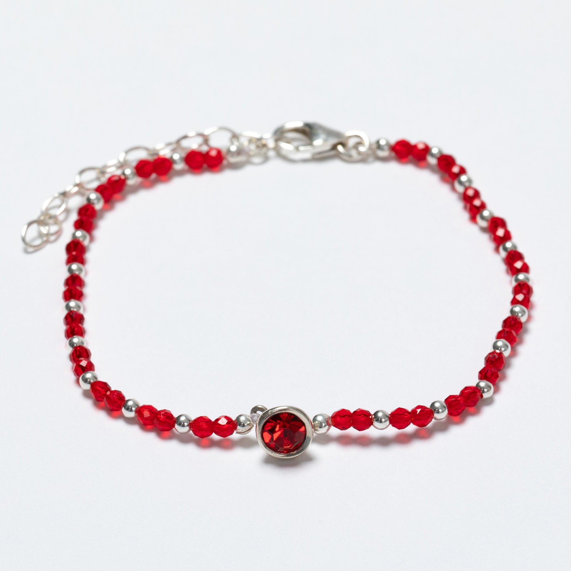 Bracelet with red beads and a silver clasp on a white background