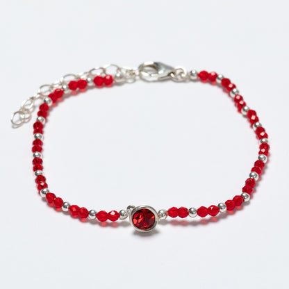 Bracelet with red beads and a silver clasp on a white background
