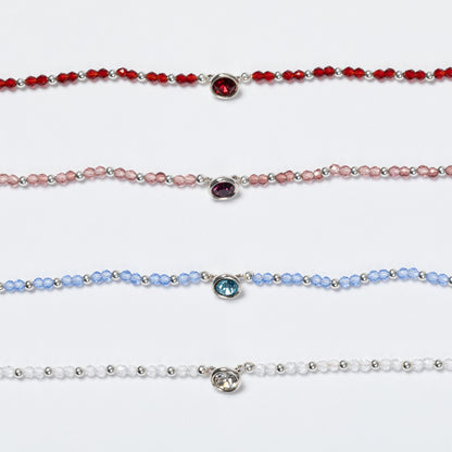 Four beaded bracelets with colored gemstones on a white background