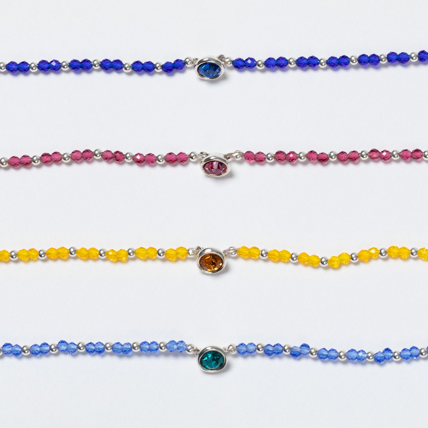 Set of colorful beaded bracelets with gemstones on a white background