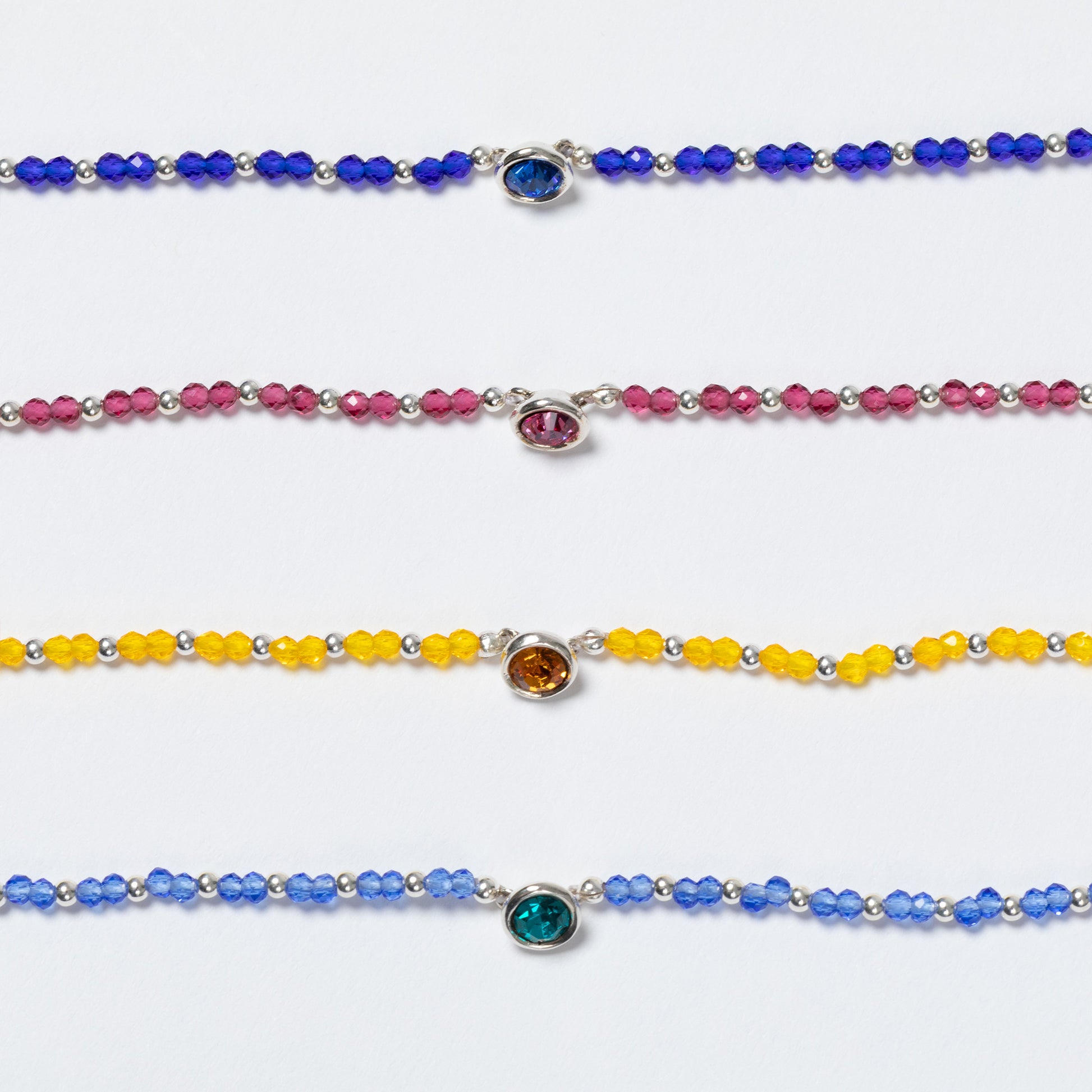 Set of colorful beaded bracelets with gemstones on a white background