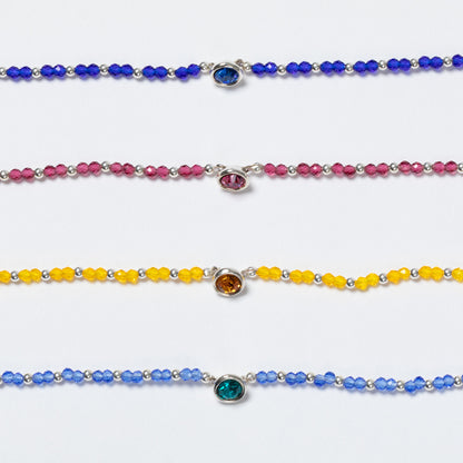 Set of colorful beaded bracelets with gemstones on a white background