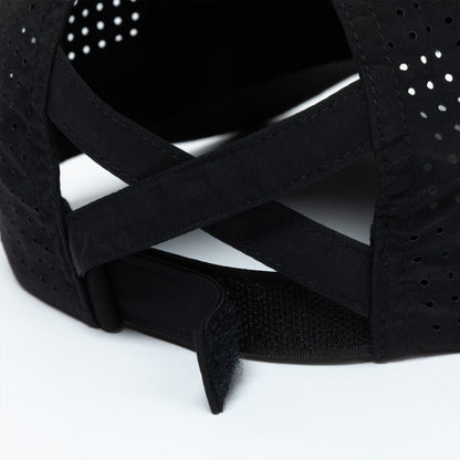 Black cap with perforated design and ponytail opening on a white background
