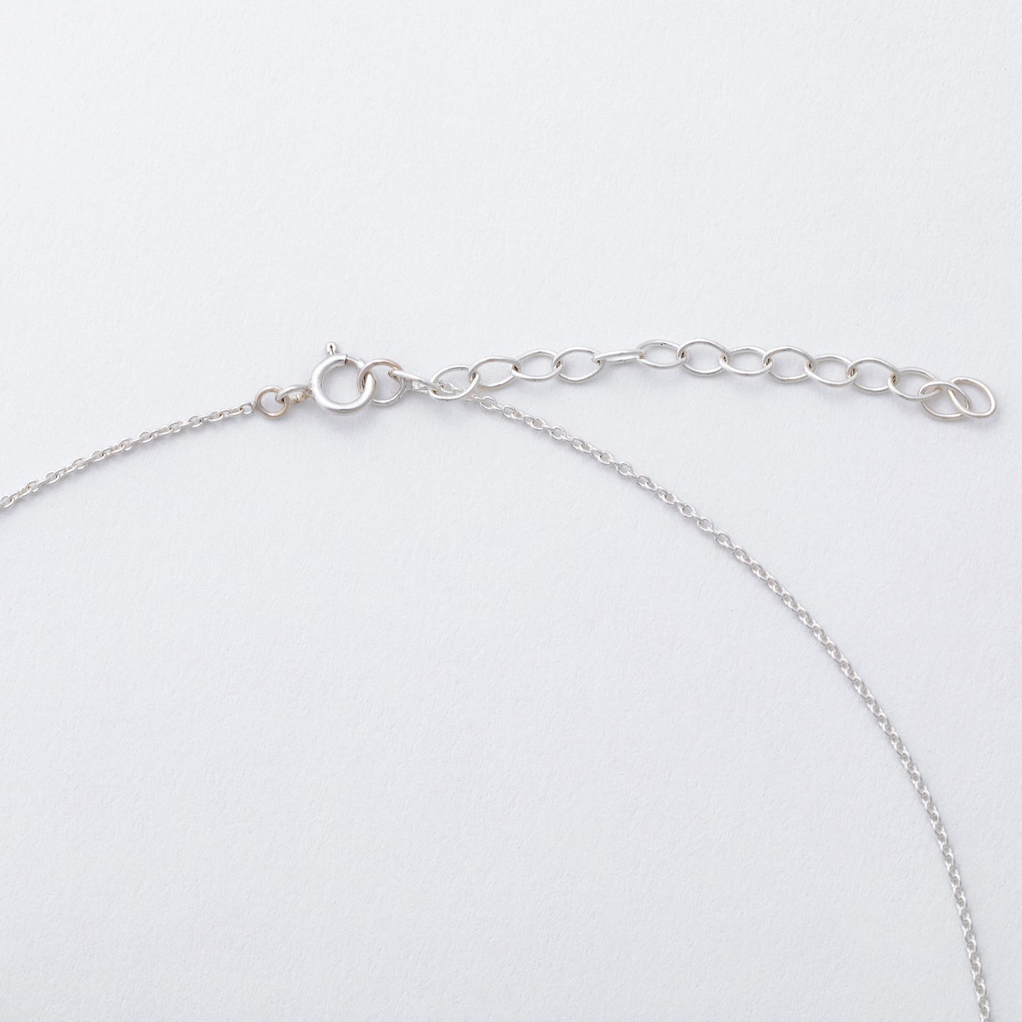 Silver chain bracelet on a light gray background