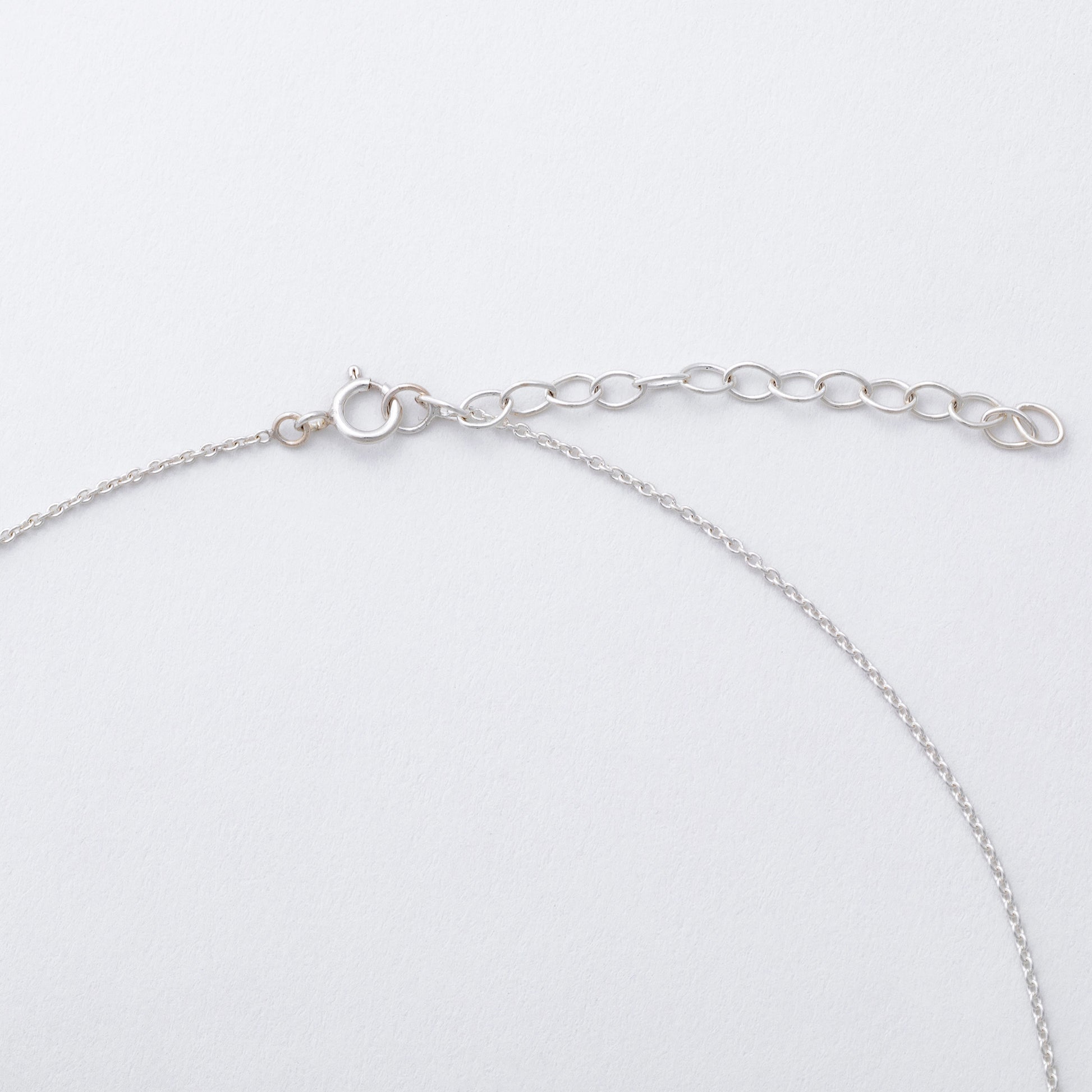 Silver chain bracelet on a light gray background