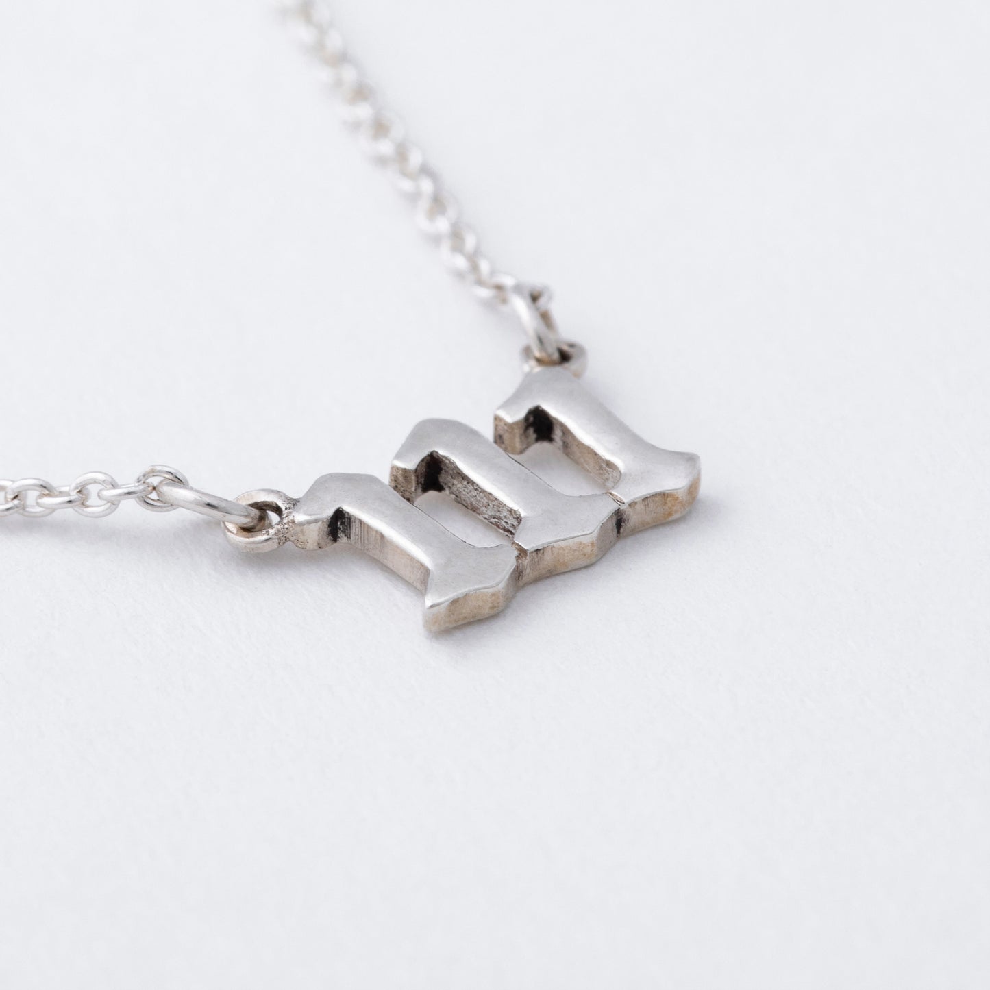 Silver necklace with a unique pendant on a light gray background