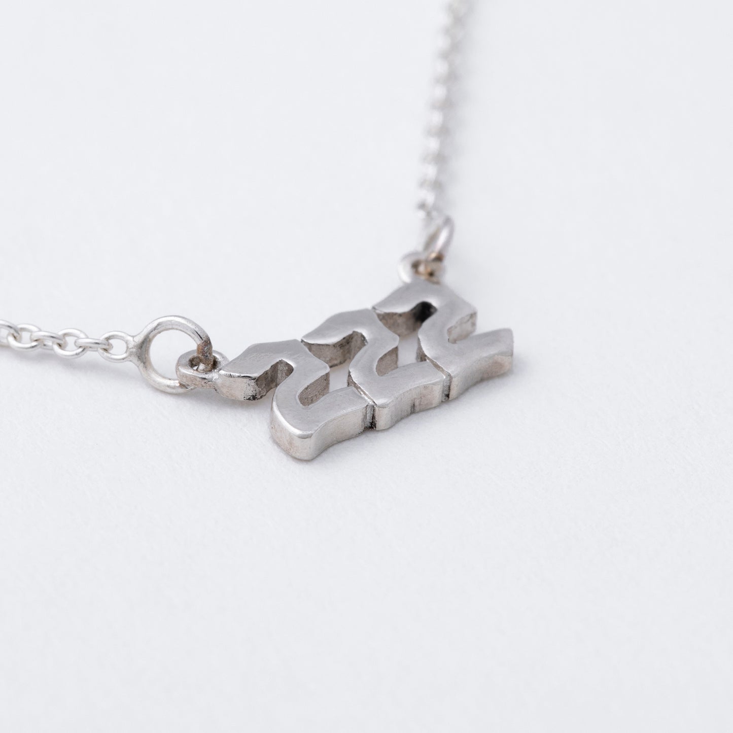 Silver necklace with a unique pendant on a white background