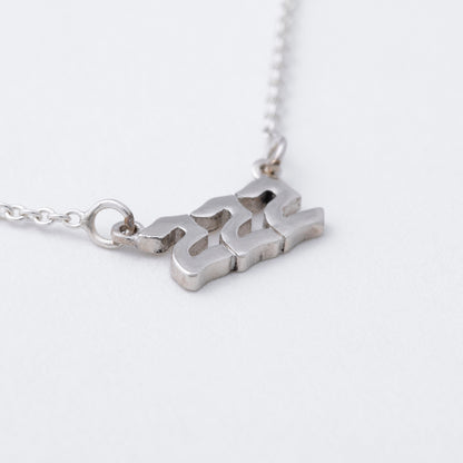 Silver necklace with a unique pendant on a white background