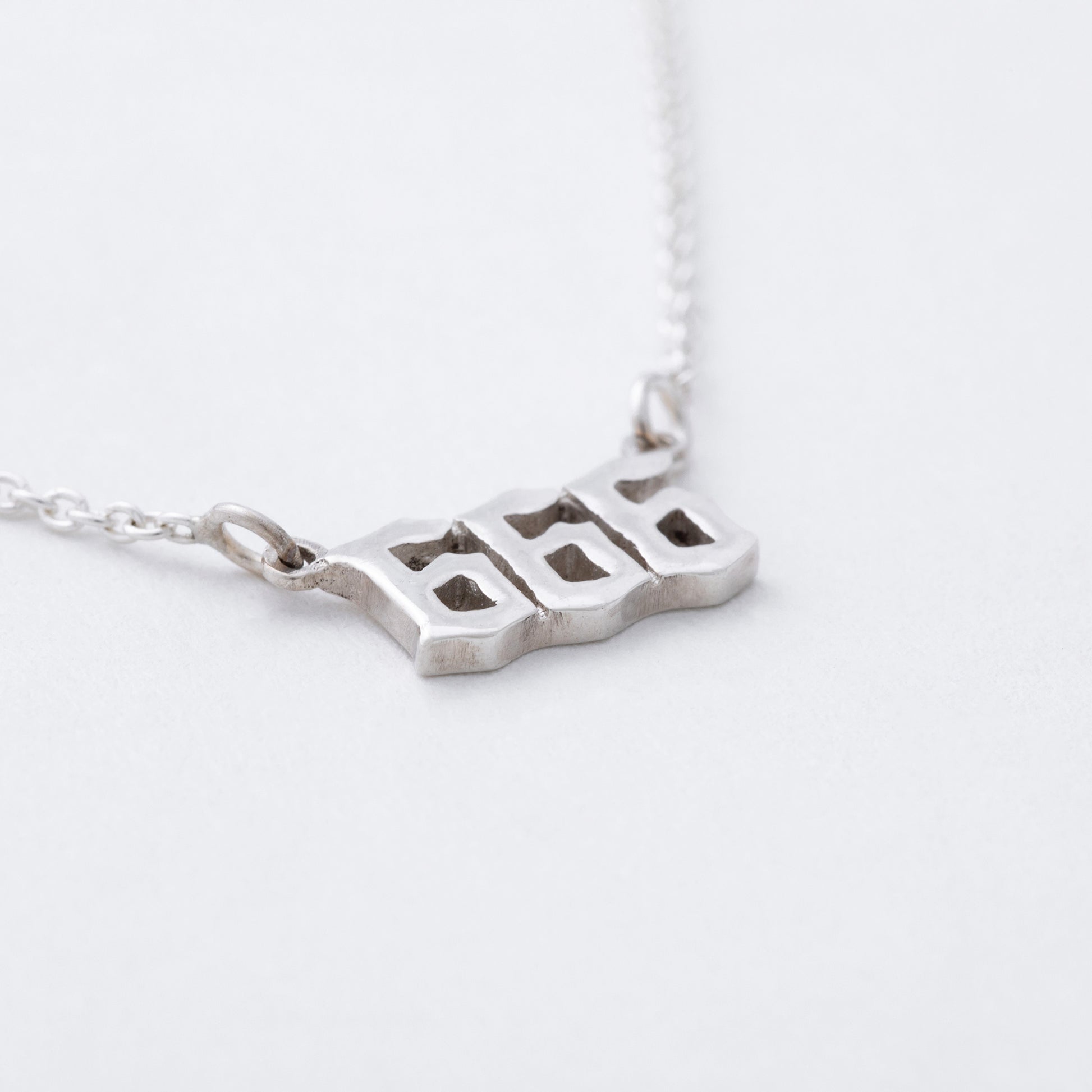 Silver necklace with a unique pendant on a white background