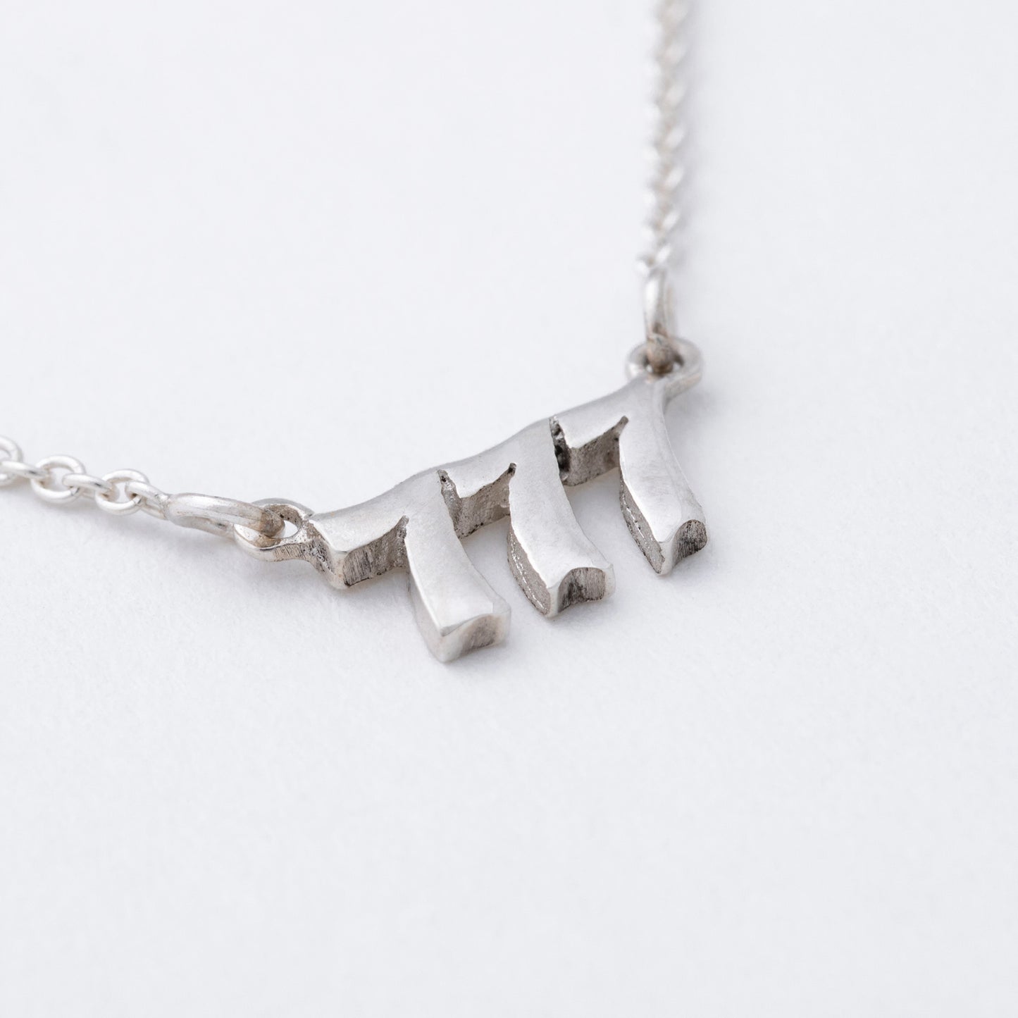 Silver necklace with a unique pendant on a white background