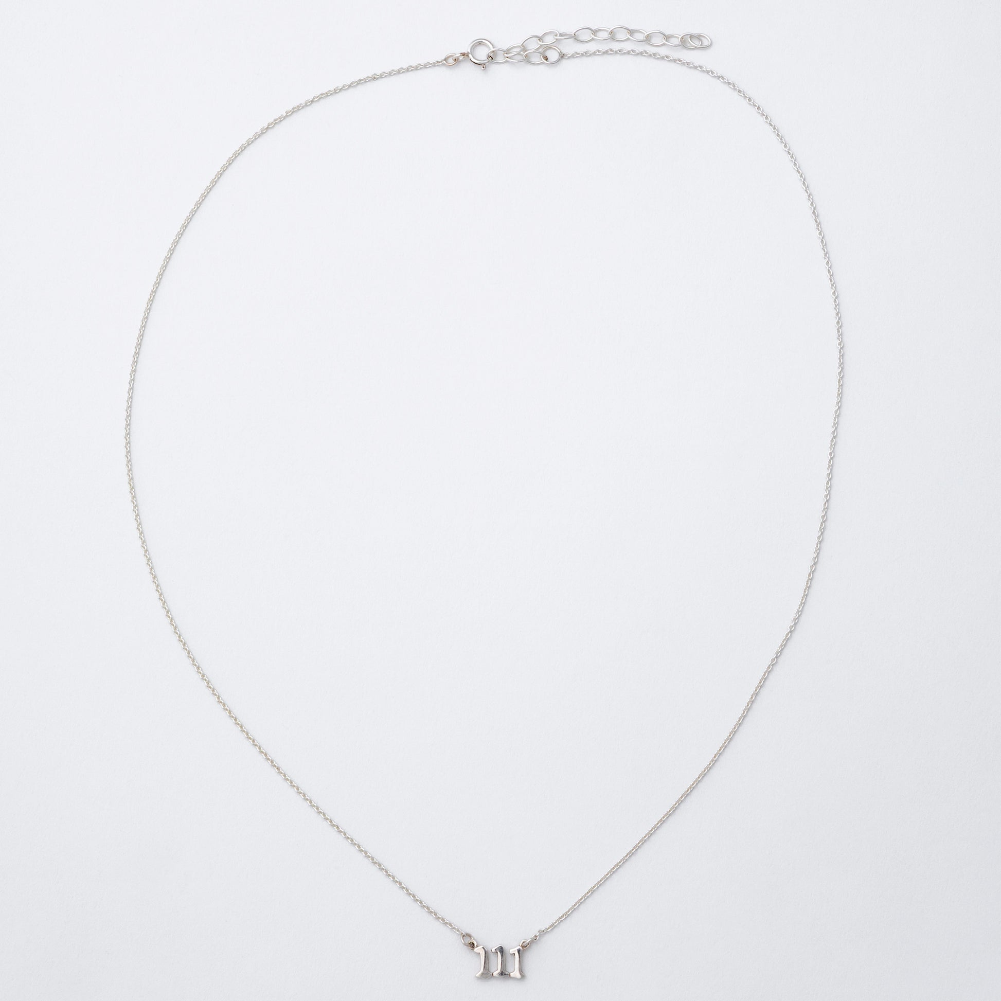 Silver necklace with a small pendant on a light gray background