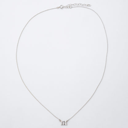 Silver necklace with a small pendant on a light gray background