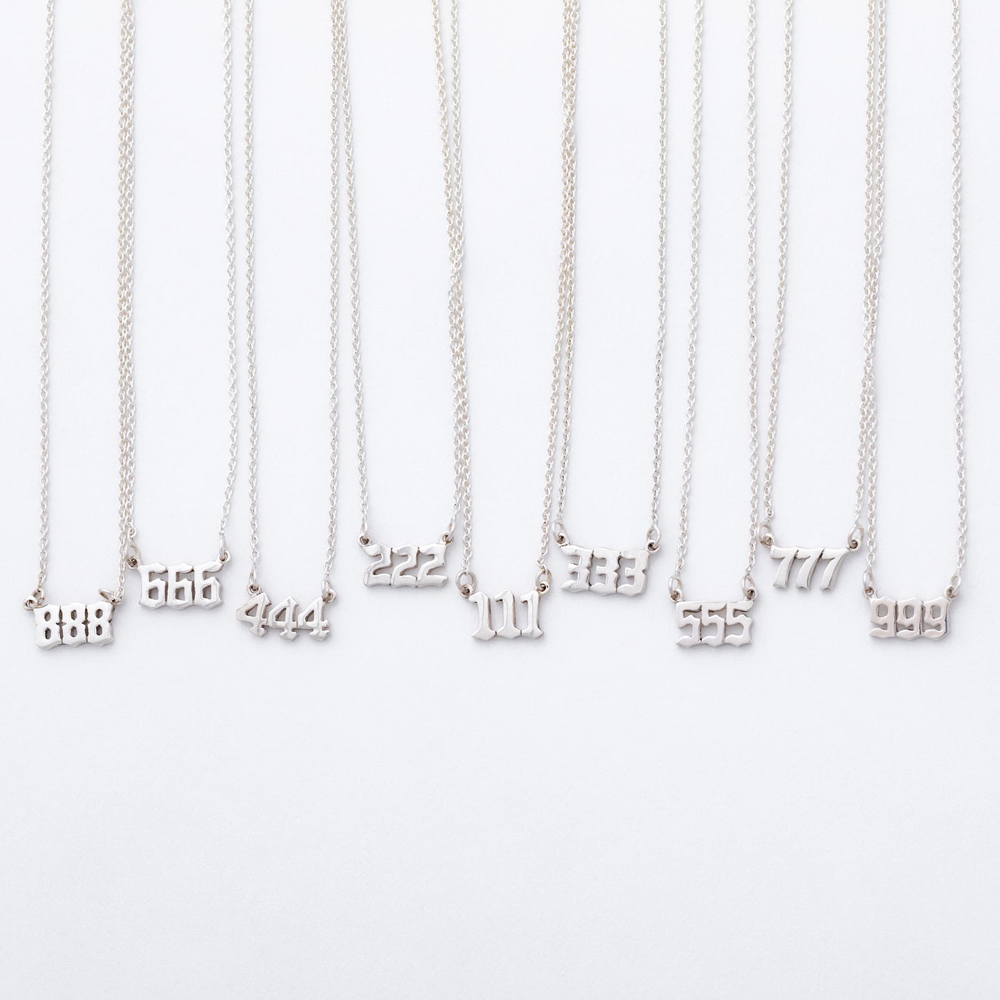 Silver necklaces with number pendants on a white background