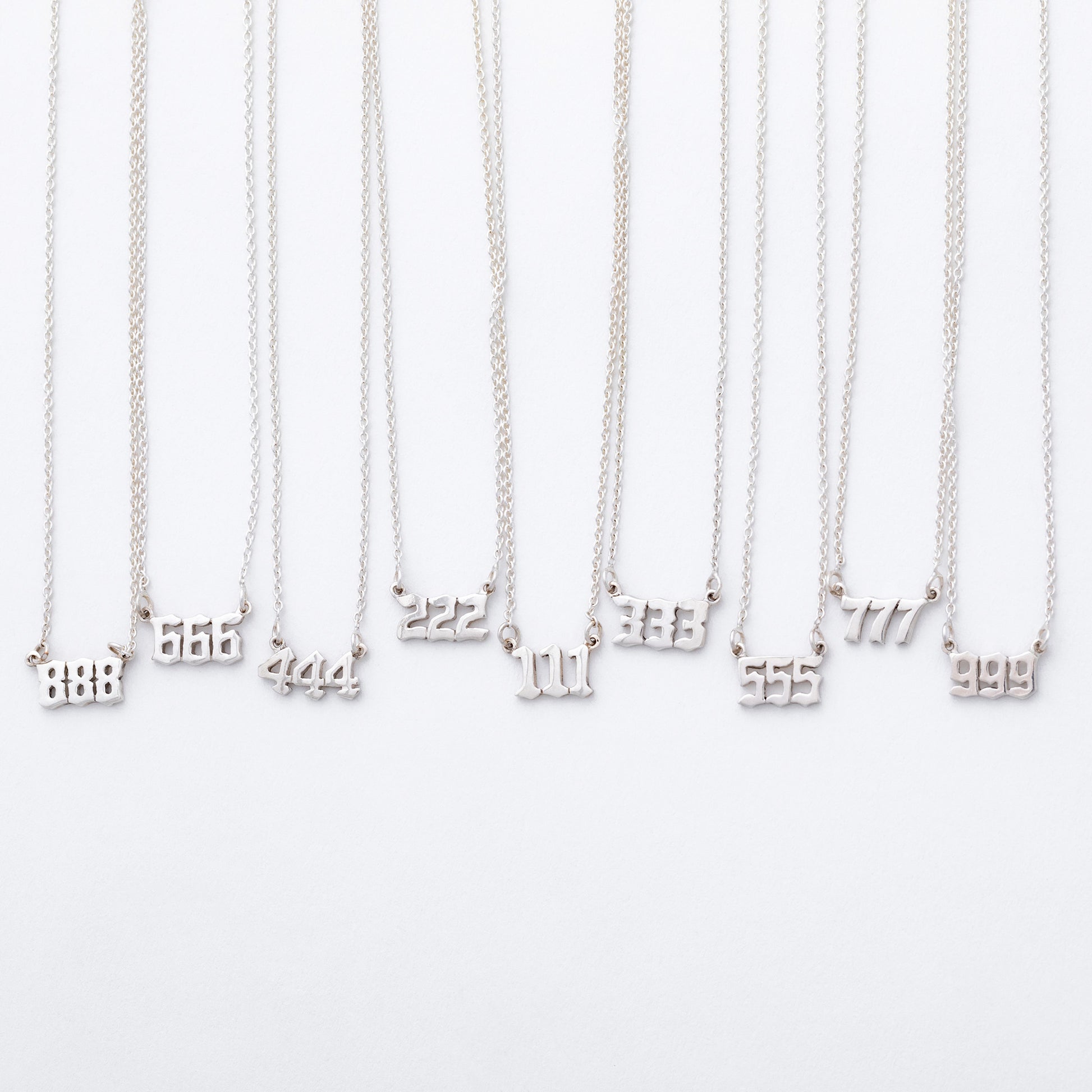 Silver necklaces with number pendants on a white background