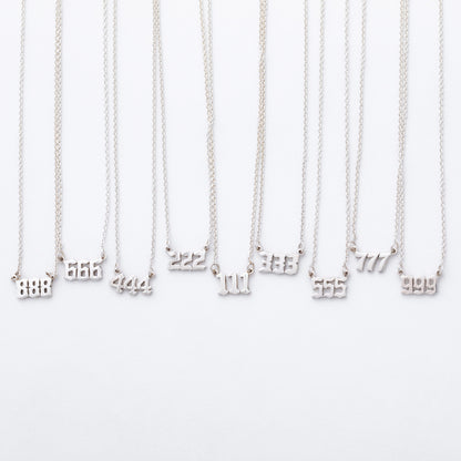 Silver necklaces with number pendants on a white background